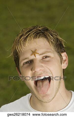 Picture - Portrait of a young man with a starfish on his forehead. Fotosearch
