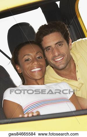 Portrait of a young woman and a mid adult man sitting in a jeep View Large Photo Image Picture - Portrait of a young woman and a mid adult man sitting in a jeep. Fotosearch