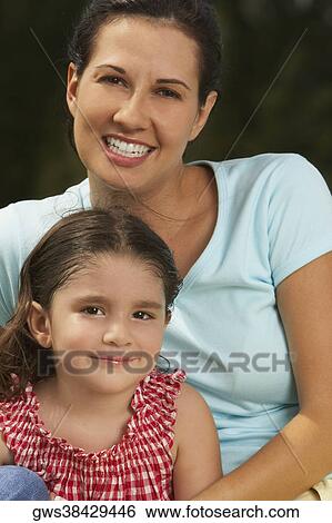 Stock Photograph - Portrait of a young woman and her daughter smiling. Fotosearch