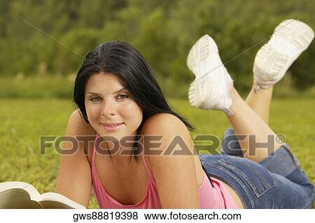 Portrait of a young woman holding a book View Large Photo Image Stock Photo - Portrait of a young woman holding a book. Fotosearch