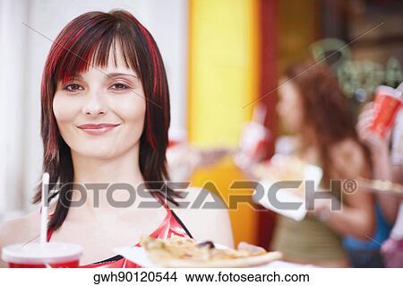 Portrait of a young woman holding a plate with a cold drink and a slice of pizza View Large Photo Image Picture - Portrait of a young woman holding a plate with a cold drink and a slice of pizza . Fotosearch