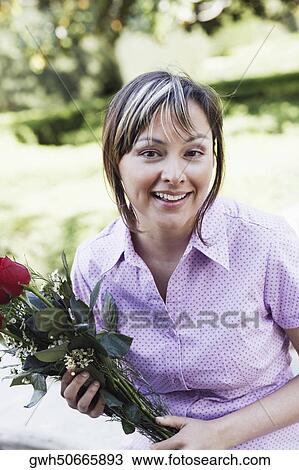 Portrait of a young woman holding a bunch of roses View Large Photo Image Stock Image - Portrait of a young woman holding a bunch of roses. Fotosearch