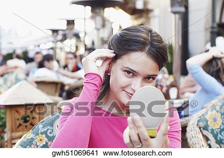 Portrait of a young woman holding a vanity mirror View Large Photo Image Stock Image - Portrait of a young woman holding a vanity mirror . Fotosearch