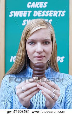 Portrait of a young woman holding a chocolate View Large Photo Image Stock Image - Portrait of a young woman holding a chocolate. Fotosearch
