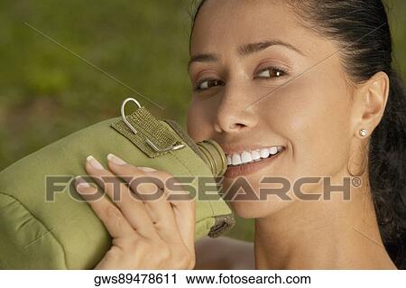 Portrait of a young woman holding a water bottle View Large Photo Image Stock Image - Portrait of a young woman holding a water bottle. Fotosearch