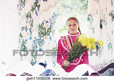 Stock Photo - Portrait of a young woman holding a bunch of flowers. Fotosearch
