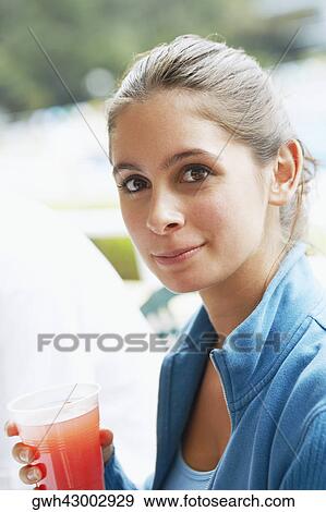 Stock Photo - Portrait of a young woman holding a glass. Fotosearch