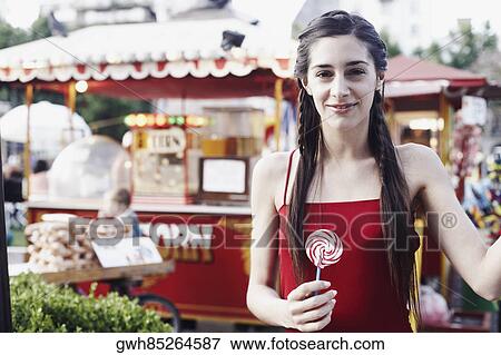 Stock Photo - Portrait of a young woman holding a lollipop . Fotosearch