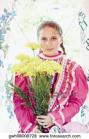 Portrait of a young woman holding a bunch of flowers View Large Photo Image Stock Photo - Portrait of a young woman holding a bunch of flowers. Fotosearch