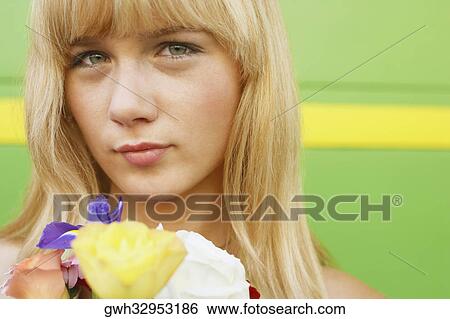 Stock Photograph - Portrait of a young woman holding a bouquet of flowers. Fotosearch
