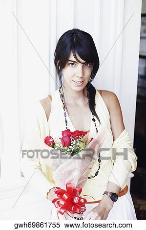 Stock Photography - Portrait of a young woman holding a bouquet of flowers. Fotosearch