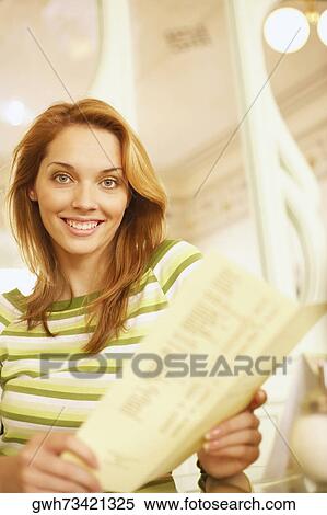 Portrait of a young woman holding a menu card View Large Photo Image Stock Photography - Portrait of a young woman holding a menu card . Fotosearch