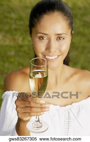Portrait of a young woman holding a champagne flute View Large Photo Image Stock Photography - Portrait of a young woman holding a champagne flute. Fotosearch