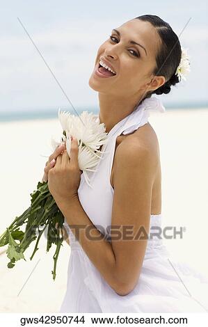 Portrait of a young woman holding flowers and laughing View Large Photo Image Picture - Portrait of a young woman holding flowers and laughing. Fotosearch