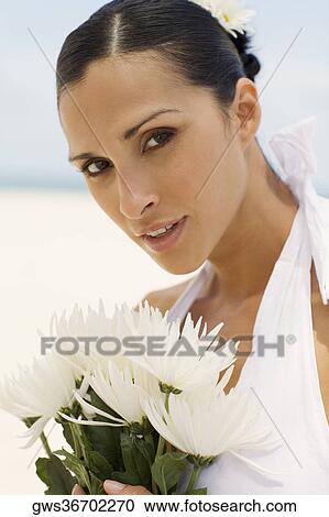 Portrait of a young woman holding flowers View Large Photo Image Stock Image - Portrait of a young woman holding flowers. Fotosearch
