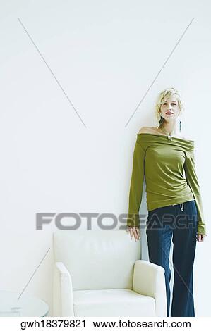 Portrait of a young woman leaning against a wall View Large Photo Image Stock Image - Portrait of a young woman leaning against a wall. Fotosearch