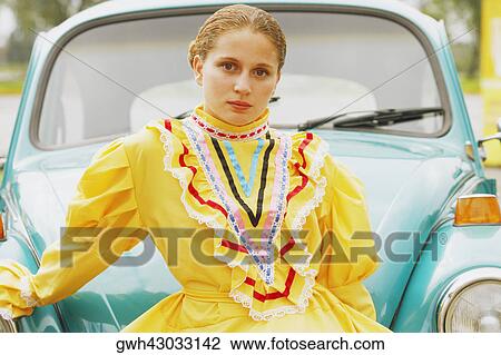 Portrait of a young woman leaning against a car View Large Photo Image Stock Image - Portrait of a young woman leaning against a car. Fotosearch
