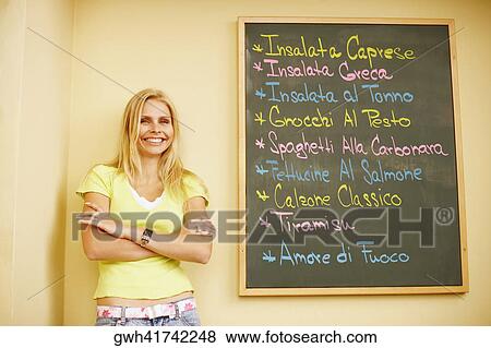 Stock Photo - Portrait of a young woman leaning against a wall . Fotosearch