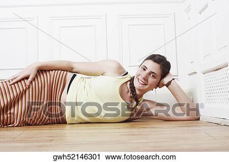 Portrait of a young woman lying on the floor View Large Photo Image Stock Image - Portrait of a young woman lying on the floor. Fotosearch