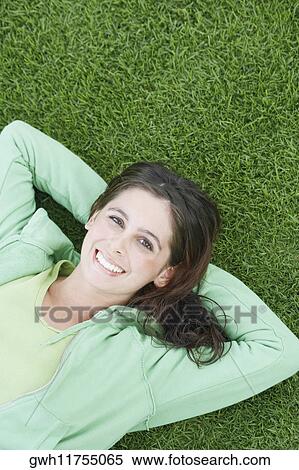 Portrait of a young woman lying on the grass and smiling View Large Photo Image Stock Photography - Portrait of a young woman lying on the grass and smiling. Fotosearch