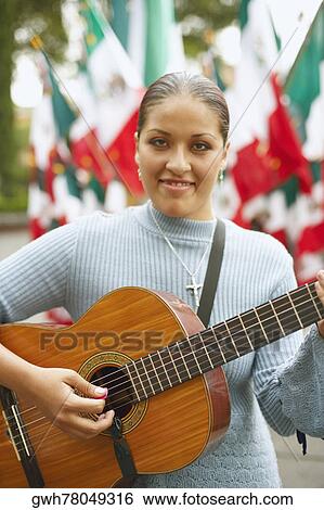 Portrait of a young woman playing the guitar View Large Photo Image Stock Photograph - Portrait of a young woman playing the guitar. Fotosearch