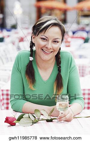 Portrait of a young woman sitting at a sidewalk cafe View Large Photo Image Stock Photo - Portrait of a young woman sitting at a sidewalk cafe . Fotosearch
