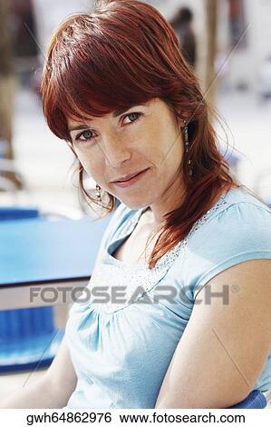 Stock Photograph - Portrait of a young woman sitting at a sidewalk cafe . Fotosearch