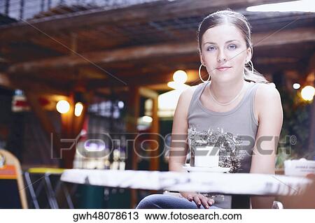 Portrait of a young woman sitting in a restaurant  View Large Photo Image Stock Image - Portrait of a young woman sitting in a restaurant . Fotosearch