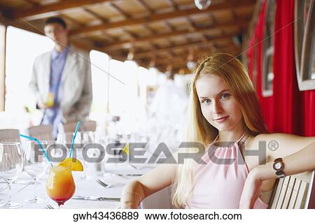 Portrait of a young woman sitting in a restaurant View Large Photo Image Stock Photo - Portrait of a young woman sitting in a restaurant . Fotosearch