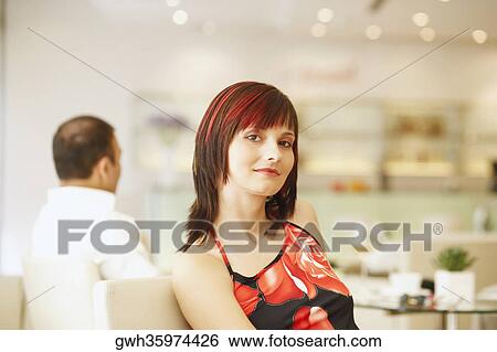 Portrait of a young woman sitting in a restaurant View Large Photo Image Stock Photograph - Portrait of a young woman sitting in a restaurant . Fotosearch