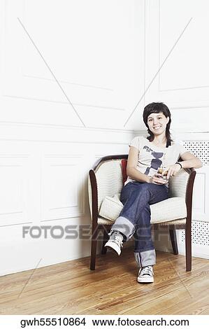 Portrait of a young woman sitting in an armchair and smiling View Large Photo Image Picture - Portrait of a young woman sitting in an armchair and smiling. Fotosearch
