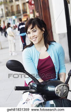 Portrait of a young woman sitting on a scooter View Large Photo Image Stock Photo - Portrait of a young woman sitting on a scooter . Fotosearch