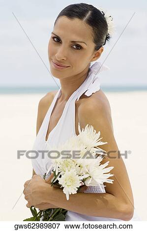 Portrait of a young woman smiling and holding flowers View Large Photo Image Stock Photo - Portrait of a young woman smiling and holding flowers. Fotosearch