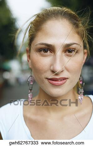 Stock Image - Portrait of a young woman smirking. Fotosearch