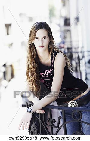 Stock Photo - Portrait of a young woman standing in the balcony . Fotosearch