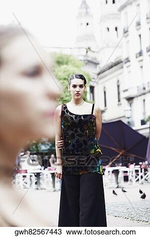 Stock Image - Portrait of a young woman standing . Fotosearch