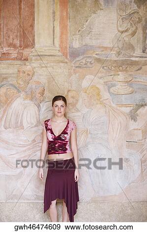 Portrait of a young woman standing against a wall View Large Photo Image Stock Photo - Portrait of a young woman standing against a wall . Fotosearch