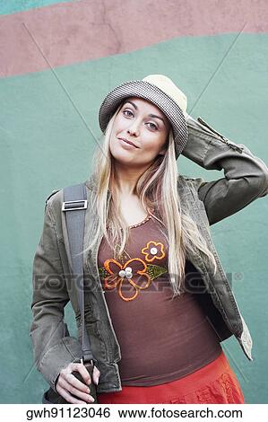 Portrait of a young woman standing with her hand on her head View Large Photo Image Stock Photograph - Portrait of a young woman standing with her hand on her head. Fotosearch
