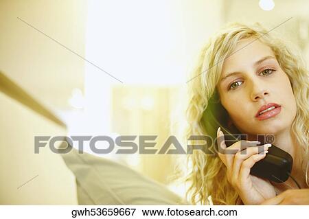 Portrait of a young woman talking on the telephone View Large Photo Image Stock Photo - Portrait of a young woman talking on the telephone. Fotosearch