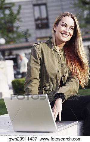 Portrait of a young woman using a laptop View Large Photo Image Stock Photo - Portrait of a young woman using a laptop . Fotosearch