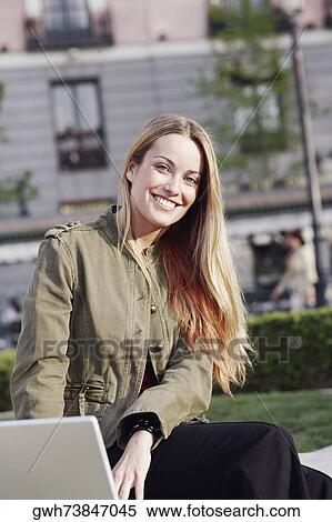 Portrait of a young woman using a laptop View Large Photo Image Stock Photography - Portrait of a young woman using a laptop . Fotosearch