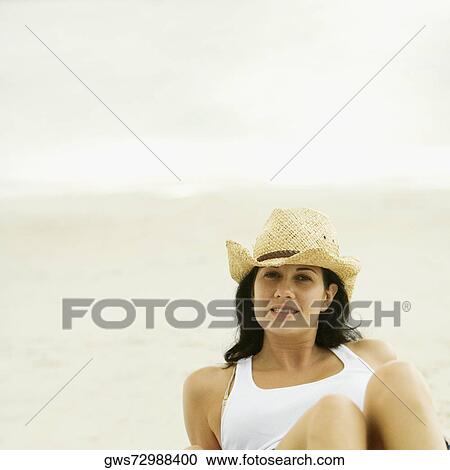 Stock Image - Portrait of a young woman wearing a sun hat. Fotosearch