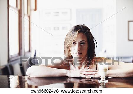 Portrait of a young woman with a glass of coffee in front of her View Large Photo Image Stock Photo - Portrait of a young woman with a glass of coffee in front of her. Fotosearch