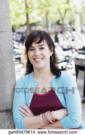 Portrait of a young woman with her arms crossed and smiling View Large Photo Image Picture - Portrait of a young woman with her arms crossed and smiling . Fotosearch