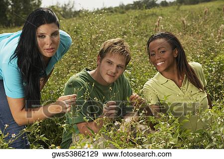 Stock Photo - Portrait of three friends in a field. Fotosearch
