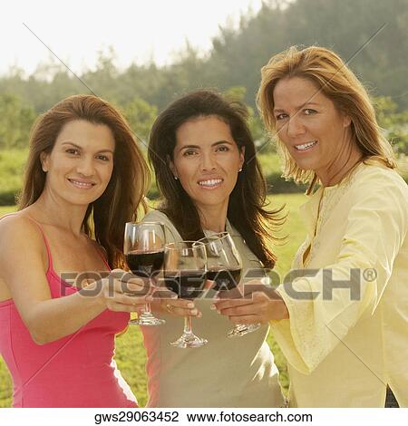 Portrait of three mid adult women holding wineglasses View Large Photo Image Stock Image - Portrait of three mid adult women holding wineglasses. Fotosearch