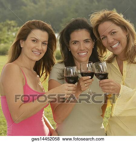 Portrait of three mid adult women holding wineglasses View Large Photo Image Stock Photo - Portrait of three mid adult women holding wineglasses. Fotosearch