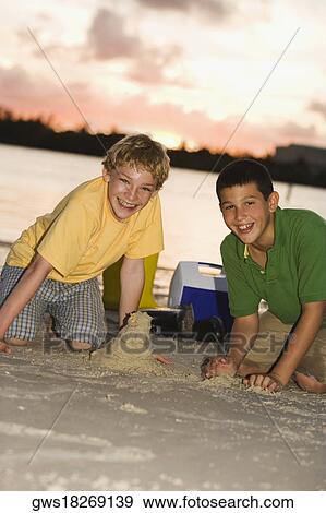 Portrait of two boys making sand castles View Large Photo Image Stock Photo - Portrait of two boys making sand castles. Fotosearch