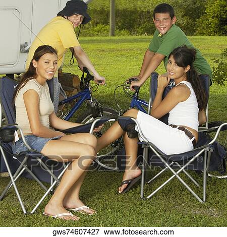 Portrait of two boys sitting on bicycles with two teenage girls sitting on armchairs and smiling View Large Photo Image Stock Photo - Portrait of two boys sitting on bicycles with two teenage girls sitting on armchairs and smiling. Fotosearch