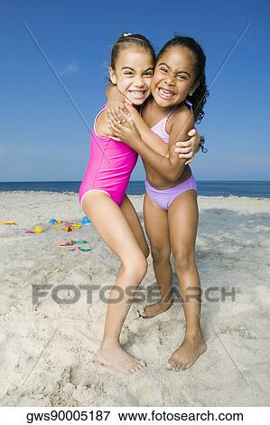Portrait of two girls hugging each other on the beach View Large Photo Image Stock Photo - Portrait of two girls hugging each other on the beach. Fotosearch